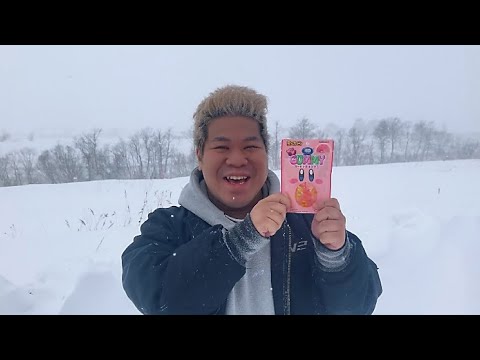 猛吹雪の中、とても美味しいグミを見つけ笑顔で紹介する男性。